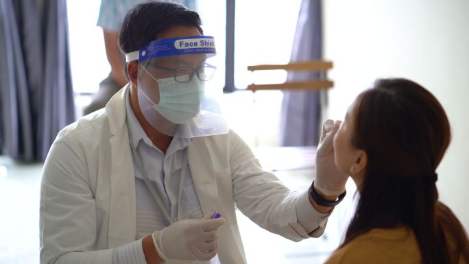 医生为女患者做冠状病毒鼻拭子检测