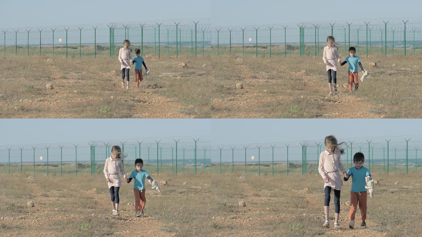 两个孩子带着玩具，沿着沙漠行走