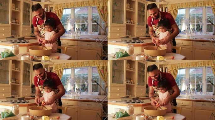 父亲和年幼的女儿在家里的厨房里烤面包。