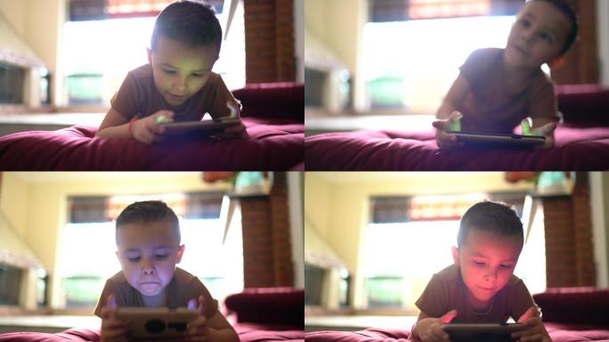 小男孩在家玩智能手机