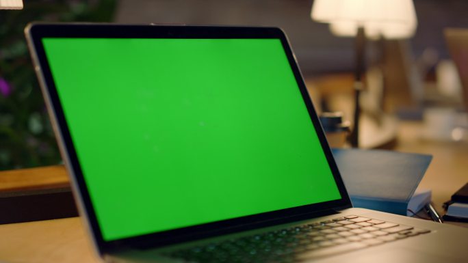 一个男子正在操作绿屏电脑。
