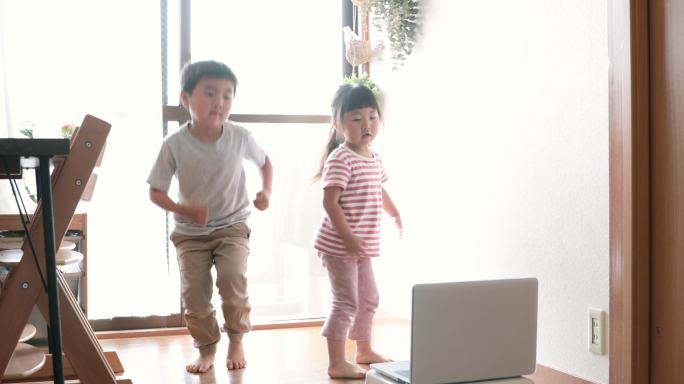 兄弟姐妹在家看笔记本电脑和跳舞