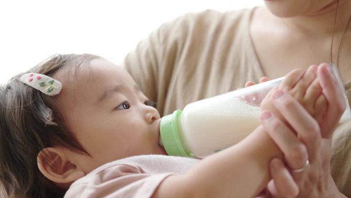 客厅里的年轻母亲在喂婴儿喝奶
