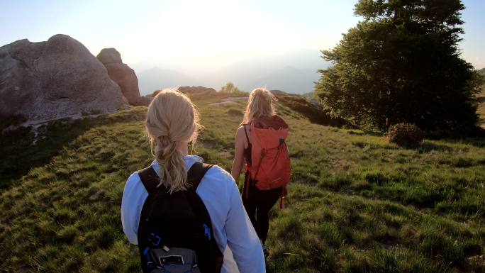 日出时，两个女人沿着山脊行走