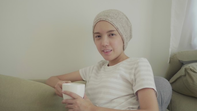 患有癌症的快乐女人喝茶。