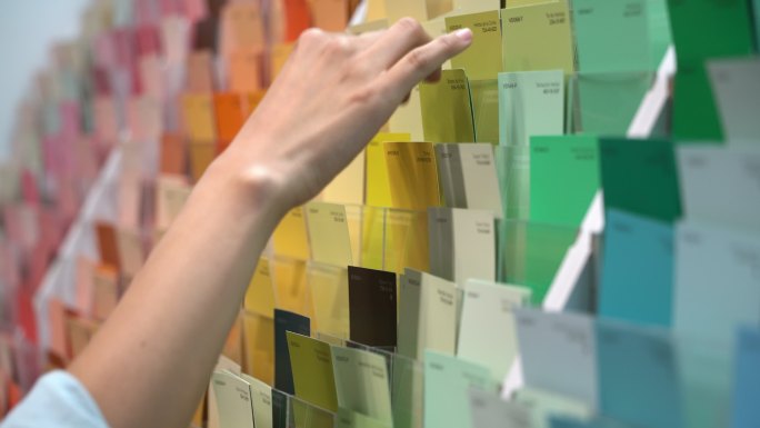 在一家油漆店的女顾客正在查看颜色样本