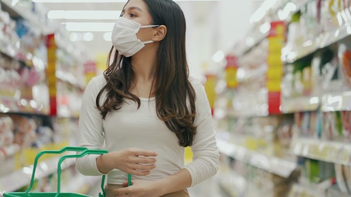 女子戴着口罩在超市购物