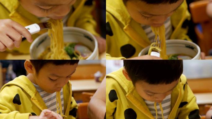 小男孩在餐馆吃面条。