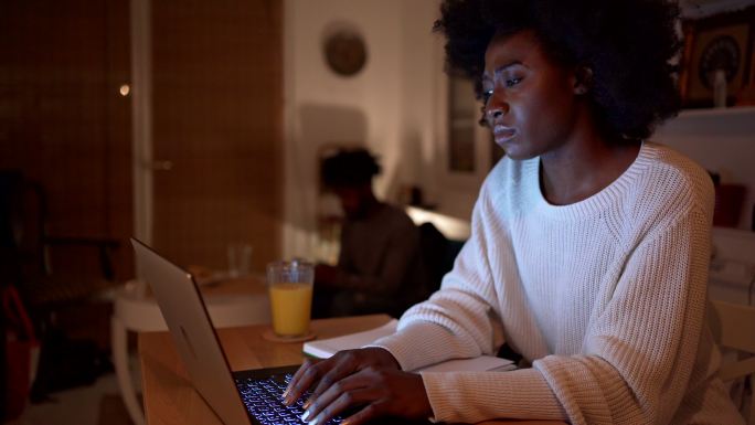 女性深夜用笔记本电脑上网找工作