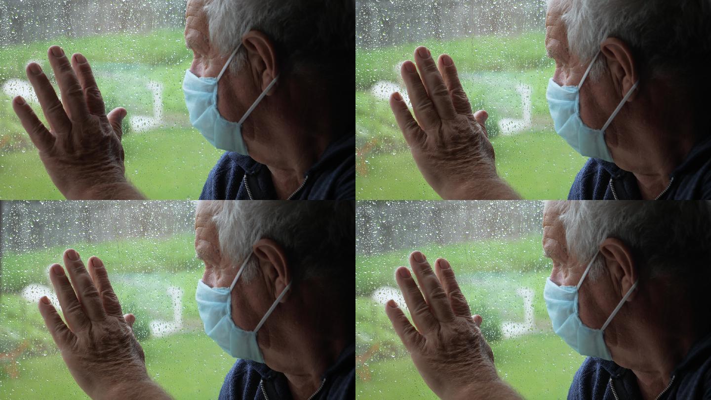 戴着医用口罩的老人看着窗外