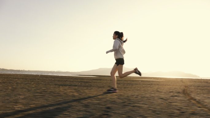 女跑步者在海滩上进行快速跑步训练