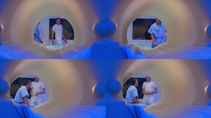 男性患者坐在核磁共振成像机的桌子上