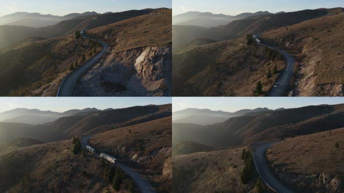 无人机拍摄的卡车沿着山口行驶的画面。