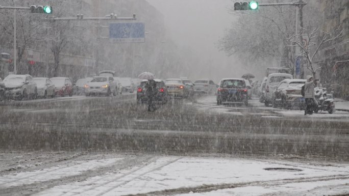 城市冬季下大雪车辆和行人放慢行走速度