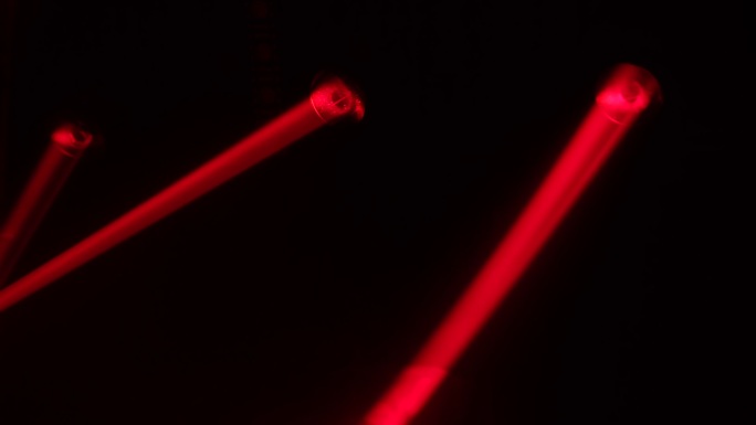 明亮的红色激光在黑暗的舞台上旋转和移动