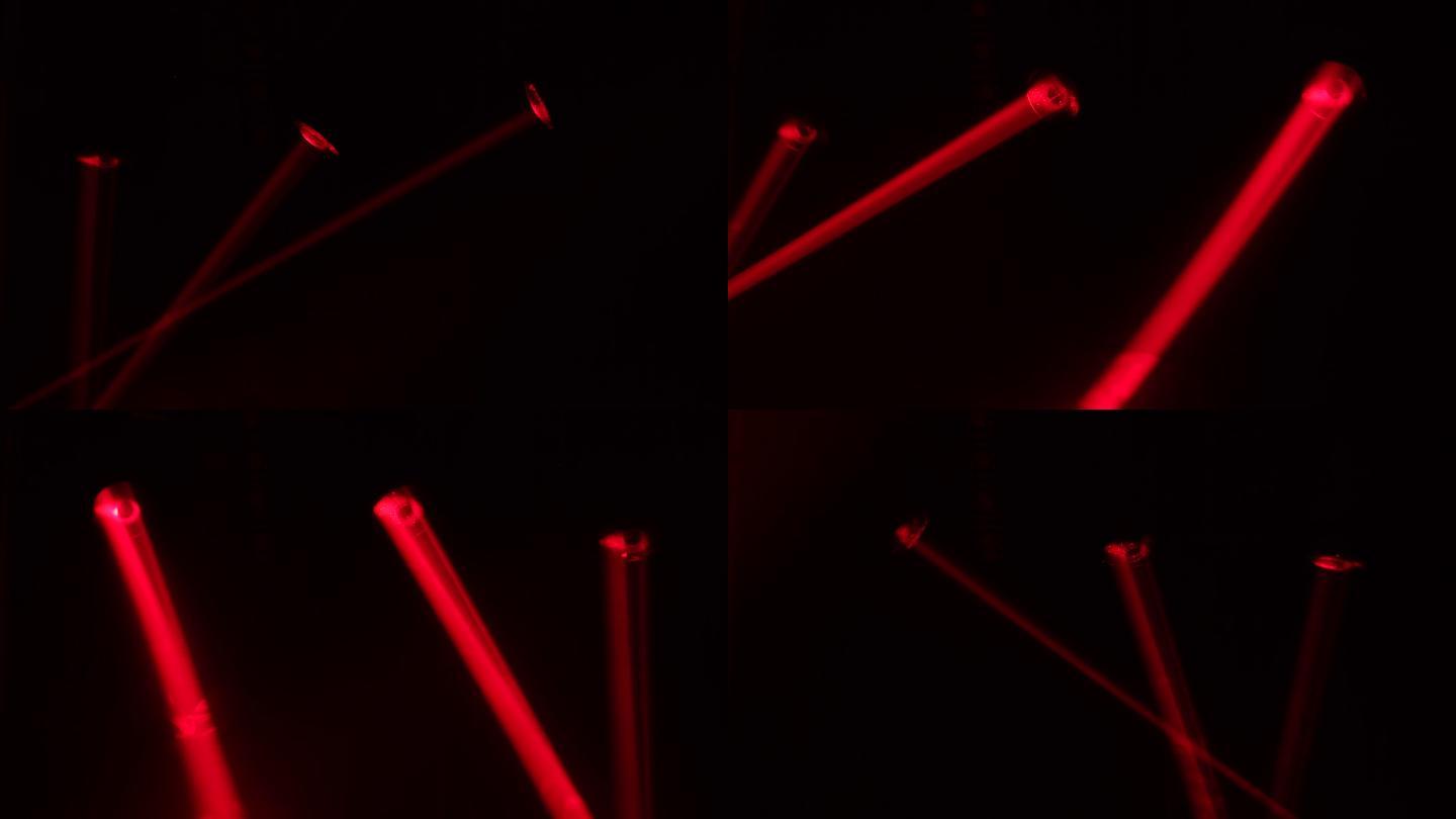 明亮的红色激光在黑暗的舞台上旋转和移动