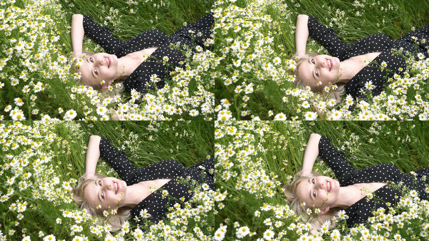 女人躺在乡间的洋甘菊花丛中