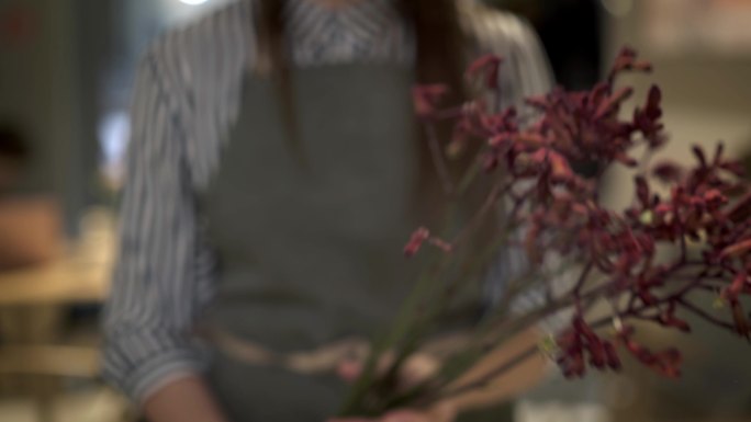 年轻女花匠拿着粉红花