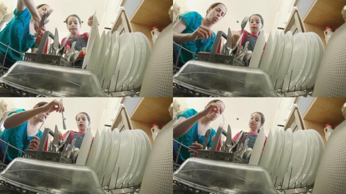 小女孩帮妈妈把脏盘子装满洗碗机