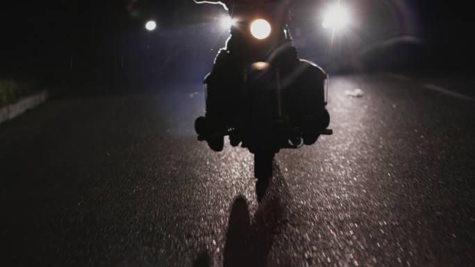 夜间骑摩托车的匿名男子