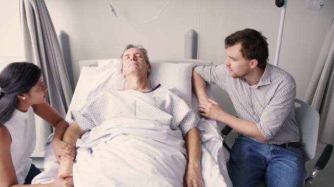 一对年轻夫妇在医院看望父亲