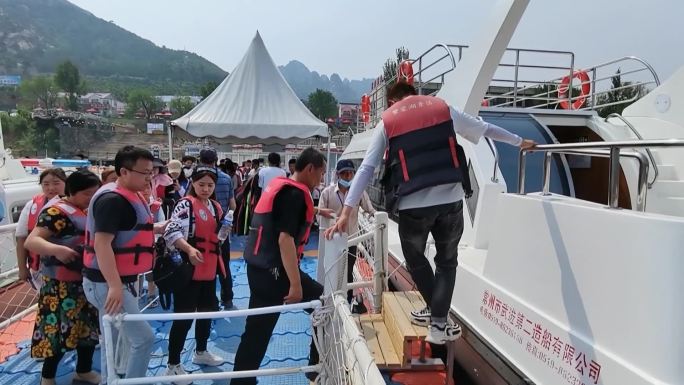 在海边湖边游客上下游艇快艇