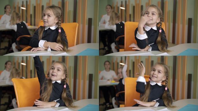 小女孩在课堂上举手回答老师的问题