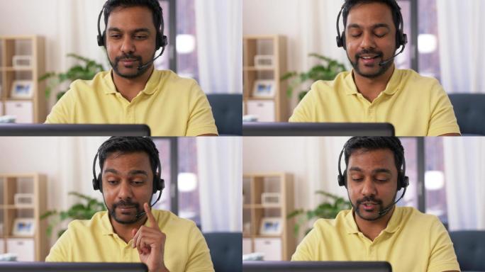印度男子戴着耳机和笔记本电脑在家工作