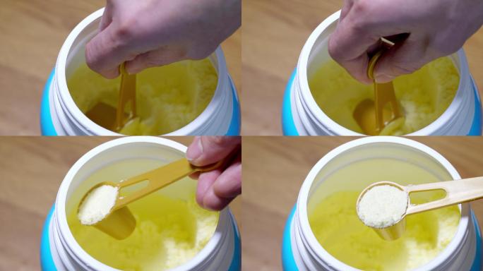 塑料罐里拿勺子舀取成人婴幼儿营养绿色奶粉