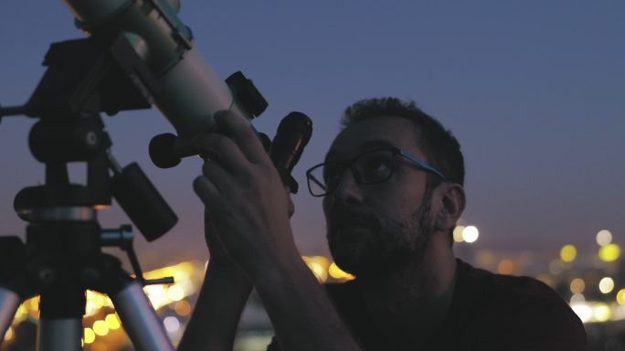 男子使用天文望远镜观察星星和月亮。