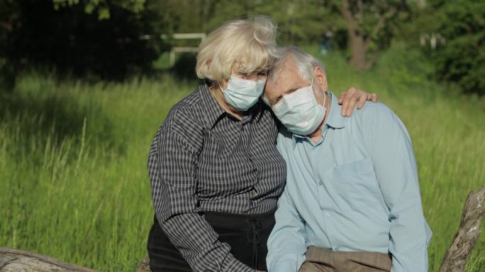 在公园戴着口罩的老年夫妇
