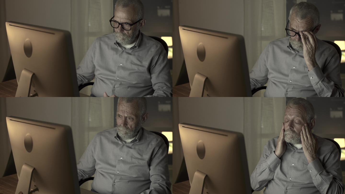 疲惫的老人晚上用电脑工作