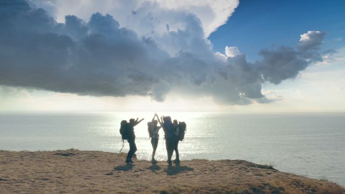 海边欢呼的人背包客徒步旅行企业团队团建