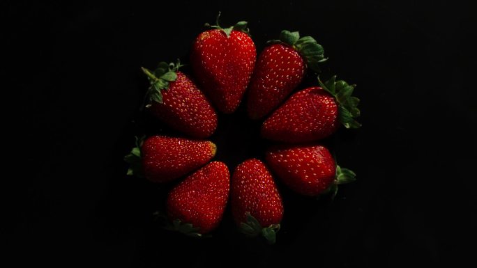 在黑色背景上压碎草莓