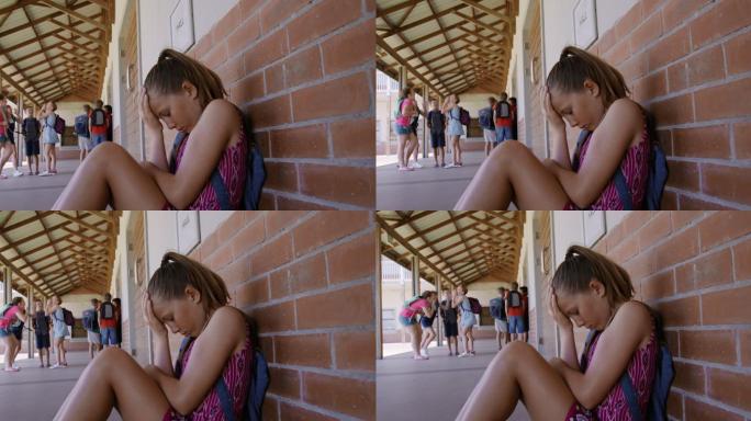 悲伤的女孩坐在学校走廊里警示教育短片