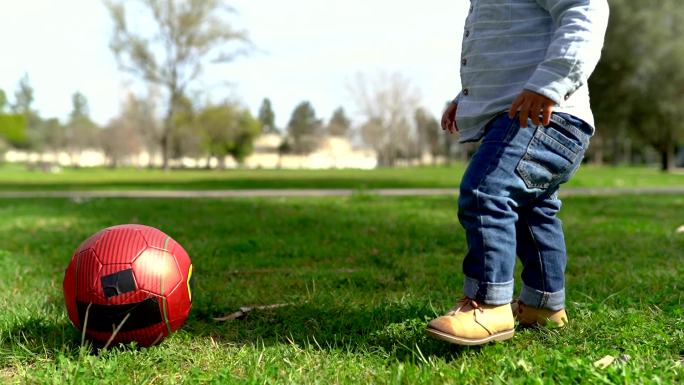 可爱的混血小男孩小孩子踢足球草坪踢球