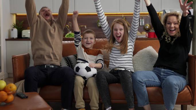 快乐的家庭在电视上看足球比赛