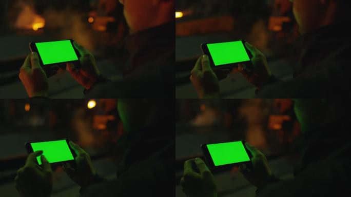 男人使用绿色屏幕的手机。