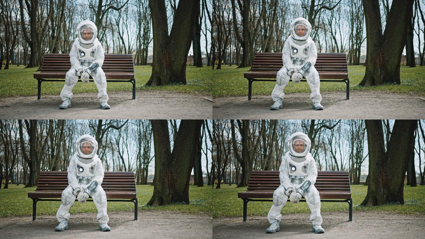 穿着太空服的悲伤男子坐在公园的长椅上