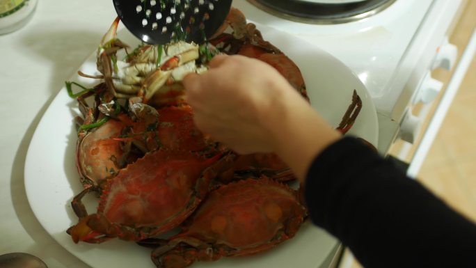 厨师从锅里拿出一盘螃蟹