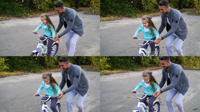 爸爸在公园教女儿骑自行车
