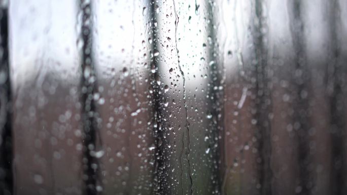 透过玻璃看雨的景象。