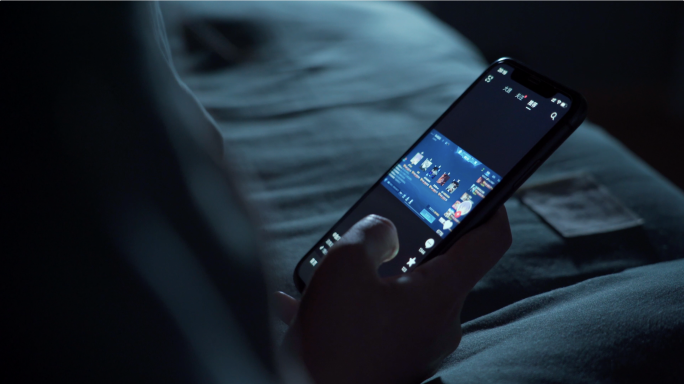 夜晚女孩在床上玩手机刷抖音