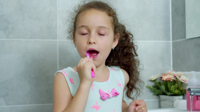 快乐可爱的少女在浴室刷牙
