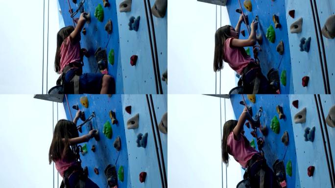 女孩穿着登山鞋和安全带爬上攀岩墙