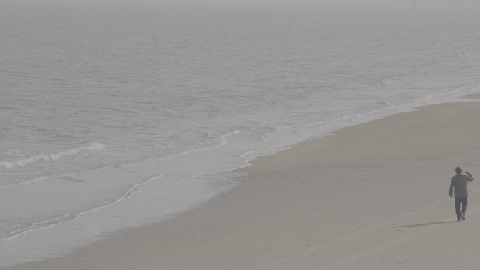 山东烟台一位孤独的老人在沙滩上漫步