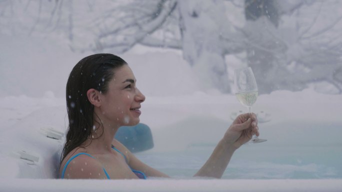 女子在热浴缸里喝着香槟