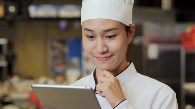 女厨师在现代厨房使用平板电脑