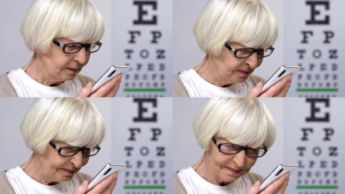 戴眼镜的老妇人在智能手机上读信息