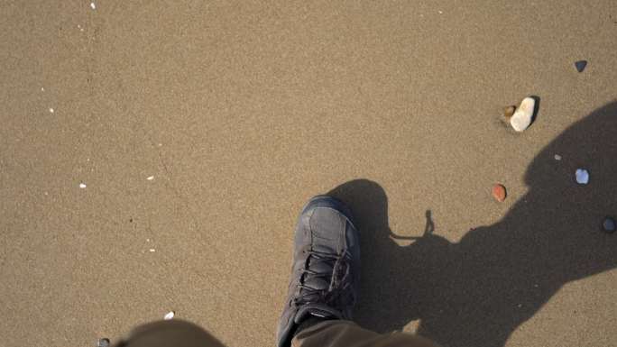 在沙滩上行走海边散步旅行旅游低头看路